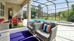 A covered outdoor area with a pool, seating, and a grill. - Modern 12 BR 11.5 BA, Sleeps 32, 15 mins to Disney (Kissimmee)