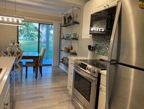 Enjoy cooking in this well-equipped kitchen with a dining table and large window offering a view of the outdoors.