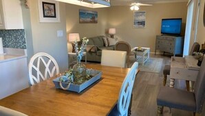 A dining area with a wooden table, white chairs, and a decorative centerpiece. - Destin, FL. Escape to Mirarmar Beach on Seascape resort (Miramar Beach)