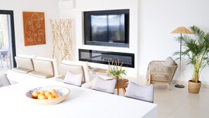 A modern living room with a sofa, TV, and dining table.
