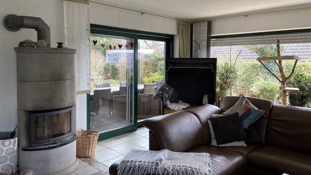 A living room with a fireplace, a sofa, and a dining area with chairs. - Quiet apartment with a great view (Wehretal)