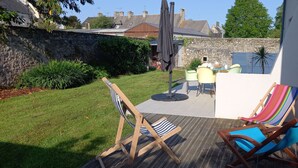 A patio with two striped chairs, a colorful hammock, and a table with chairs. - Maison de Campagne Proche mer - 5 Voyageurs (Regnéville-sur-Mer)