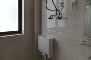 A bathroom with a shower, a wall-mounted heater, and a window. - Guzhen Inn (Wuyuan)