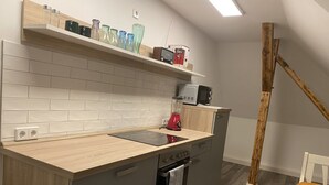 Eine moderne Küche mit Holzarbeitsplatte, eingebauten Geräten und einer Holztreppe.