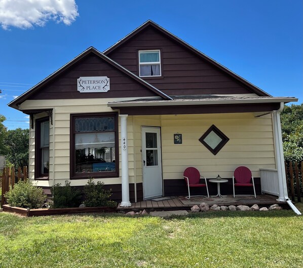 A two-story house with a porch, a sign reading "Peterson Place," and a mailbox. - Steps from restaurants and the historic Stockman’s Bar and Grill. (Walden)