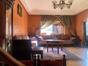Relax in this traditional living room with a large sofa, wooden coffee table, and ornate chandelier.