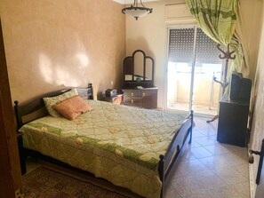 Cozy retreat with a single bed, nightstand, dresser, and TV.