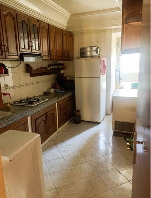 Enjoy cooking in this well-equipped kitchen with a gas stove, refrigerator, and range hood.
