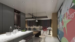 A modern kitchen with a marble countertop, a dining area with multiple tables and chairs, and a colorful mural on the wall. - Shankee Hotel (Wujiang Pedestrian Street) (Suzhou)