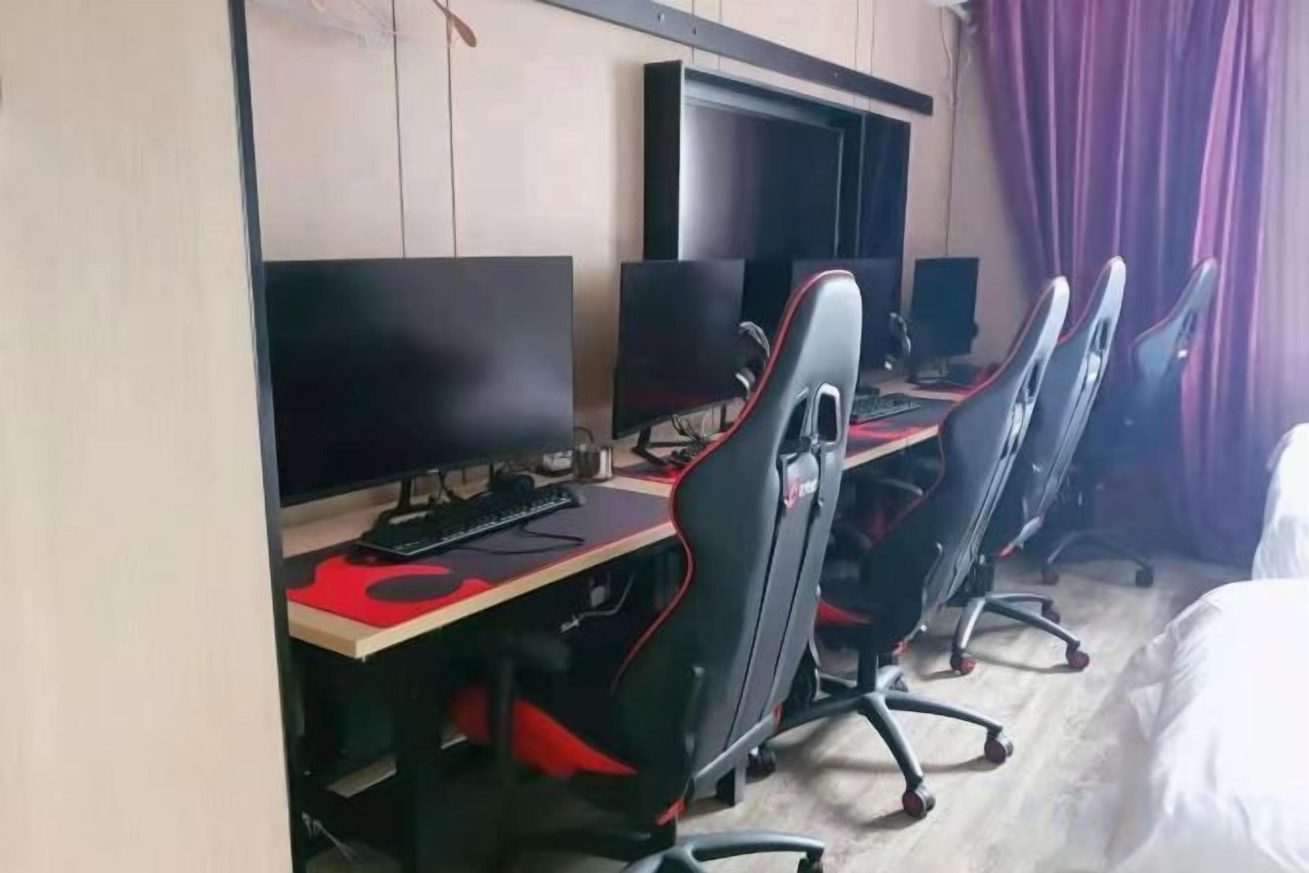 A hotel room with a desk, computer, and a bed.