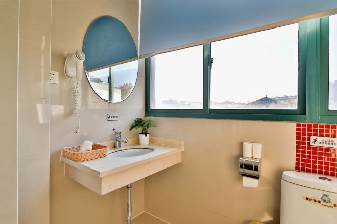 A bathroom with a sink, mirror, and toilet.