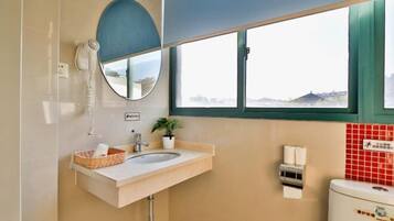 A bathroom with a sink, mirror, and toilet.