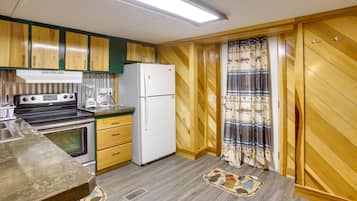 Enjoy cooking in this well-equipped kitchen with a stove, refrigerator, and coffee maker.