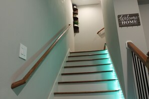 Una escalera con barandillas de madera y un cartel que dice 'Welcome HOME'.