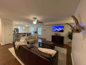 Relax in this stylish living space with a sofa, flat-screen TV, and dining area.