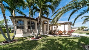 A house with a symmetrical facade, arched windows, and a central entrance. - Villa Sunset with heated Pool and Privacy on the canal (Cape Coral)