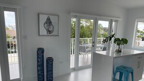 A modern kitchen with a white countertop, a blue stool, and a framed artwork on the wall. - Great House in Key Largo (Key Largo)