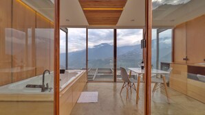 A modern bathroom with a large bathtub, a sink, and a glass-enclosed shower area.