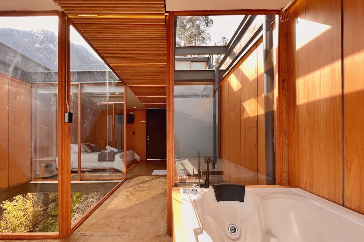 Une salle de bain moderne avec une grande baignoire, des murs en bois et une douche séparée par des parois de verre.