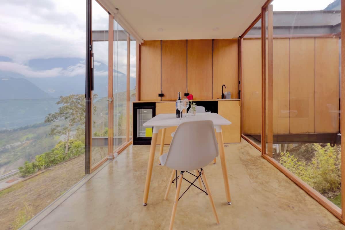 Une cuisine moderne avec des meubles en bois et un coin repas comprenant une table et des chaises.