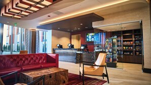 A lobby with a reception desk, seating area, and a snack bar.