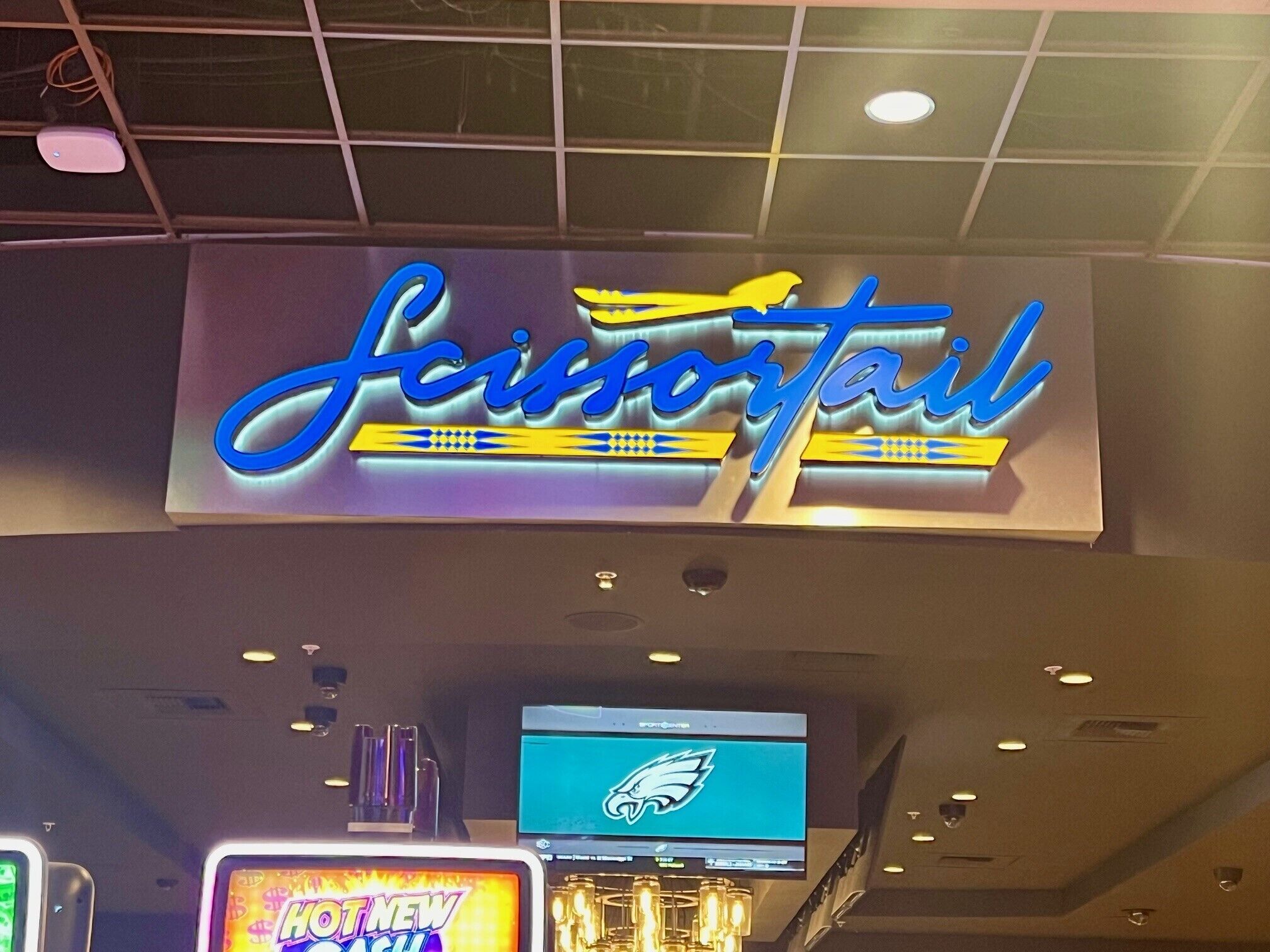 A sign for 'Scissorsail' with a sports team logo and a digital display above it.