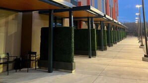 A modern building with a covered outdoor seating area and a well-lit walkway.