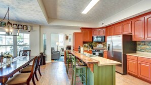 A spacious kitchen with wooden flooring, a central island, and modern appliances. - Cleveland Cabin w/ Private Hot Tub ~ 7 Mi to Helen (Cleveland)