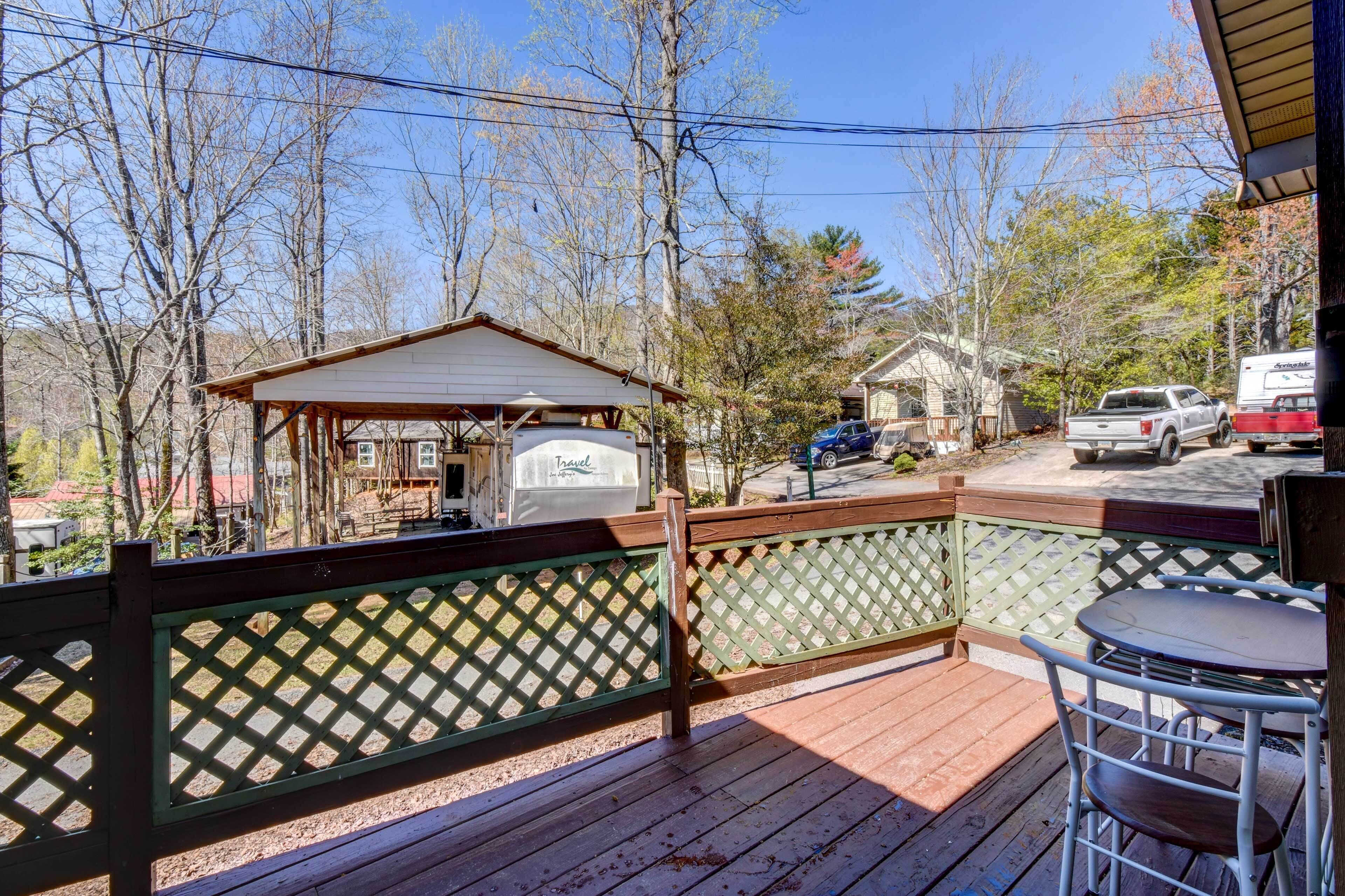 A wooden deck with a covered seating area, a small gazebo, and a travel storage box.