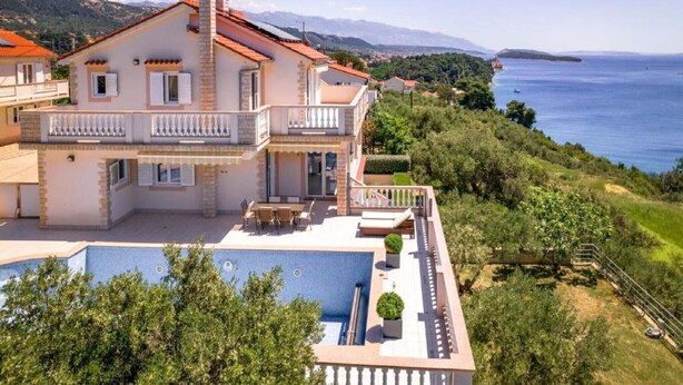 A large, two-story house with a swimming pool, a balcony, and a view of the sea. - Villa Rab Hills with Swimming Pool (Rab)