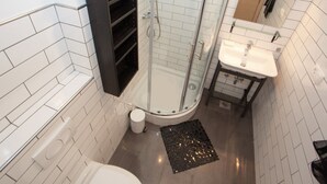 A modern bathroom with a glass-enclosed shower, a white sink, and a black rug. - Apartments & Room Vesna - Studio Apartment with Terrace and Sea View (Brela)