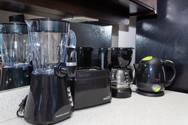 Une cuisine équipée d’un mixeur, d’un grille-pain, d’une machine à café et d’une bouilloire.