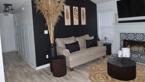 A living room with a sofa, a fireplace, and decorative wall art. - home sweet home (Rex)