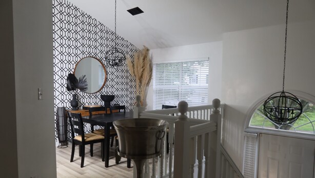 A dining area with a table, chairs, a hanging light fixture, and a window with blinds. - home sweet home (Rex)