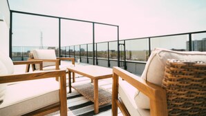 A rooftop terrace with wooden furniture and a view of the city skyline. - Chic Cozy Retreat - 2BR - Stunning North End Views (Halifax)