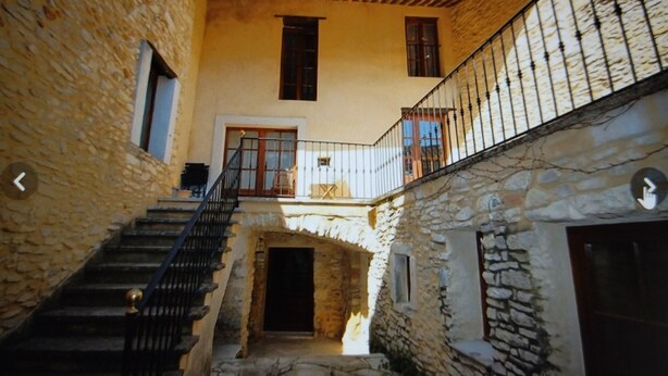 A stone building with a staircase leading to a balcony. - Proche Avignon Grande Maison calme en pierres avec cour intérieure,10 personnes (Saint Laurent des Arbres)