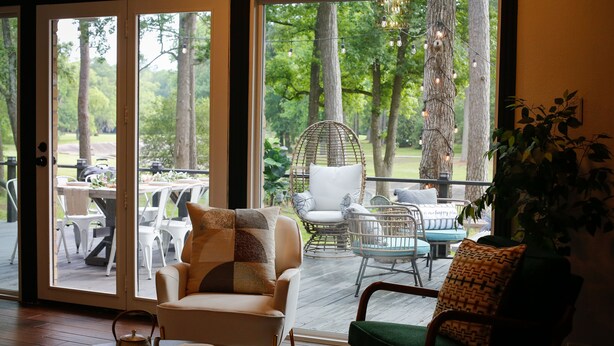 A cozy indoor seating area with a view of a deck and outdoor furniture. - Beautiful Deck with Golf Course View/ Game Room/ Fire Pit (Conroe)
