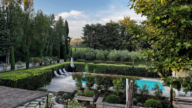 Un jardin aménagé avec une piscine, des espaces de détente et une grande variété de plantes.
