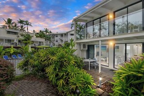 A modern hotel with a courtyard, outdoor seating, and lush greenery.