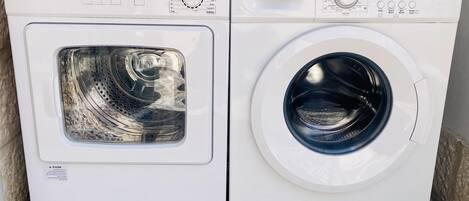 A front view of a white washing machine with a control panel, including buttons and a digital display.