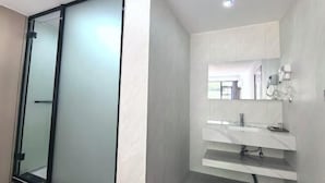 A modern bathroom with a glass shower enclosure, a white vanity with a mirror, and a recessed ceiling light. - Lubianbian Inn (Zhangjiajie)