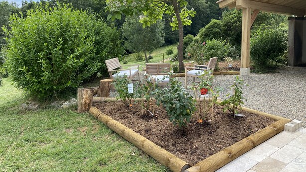 A garden area with wooden benches, a pergola, and a variety of plants. - Accomodation, bed and breakfast, equestrian reception Chemin de St Jacques Flamarens Gers (Flamarens)