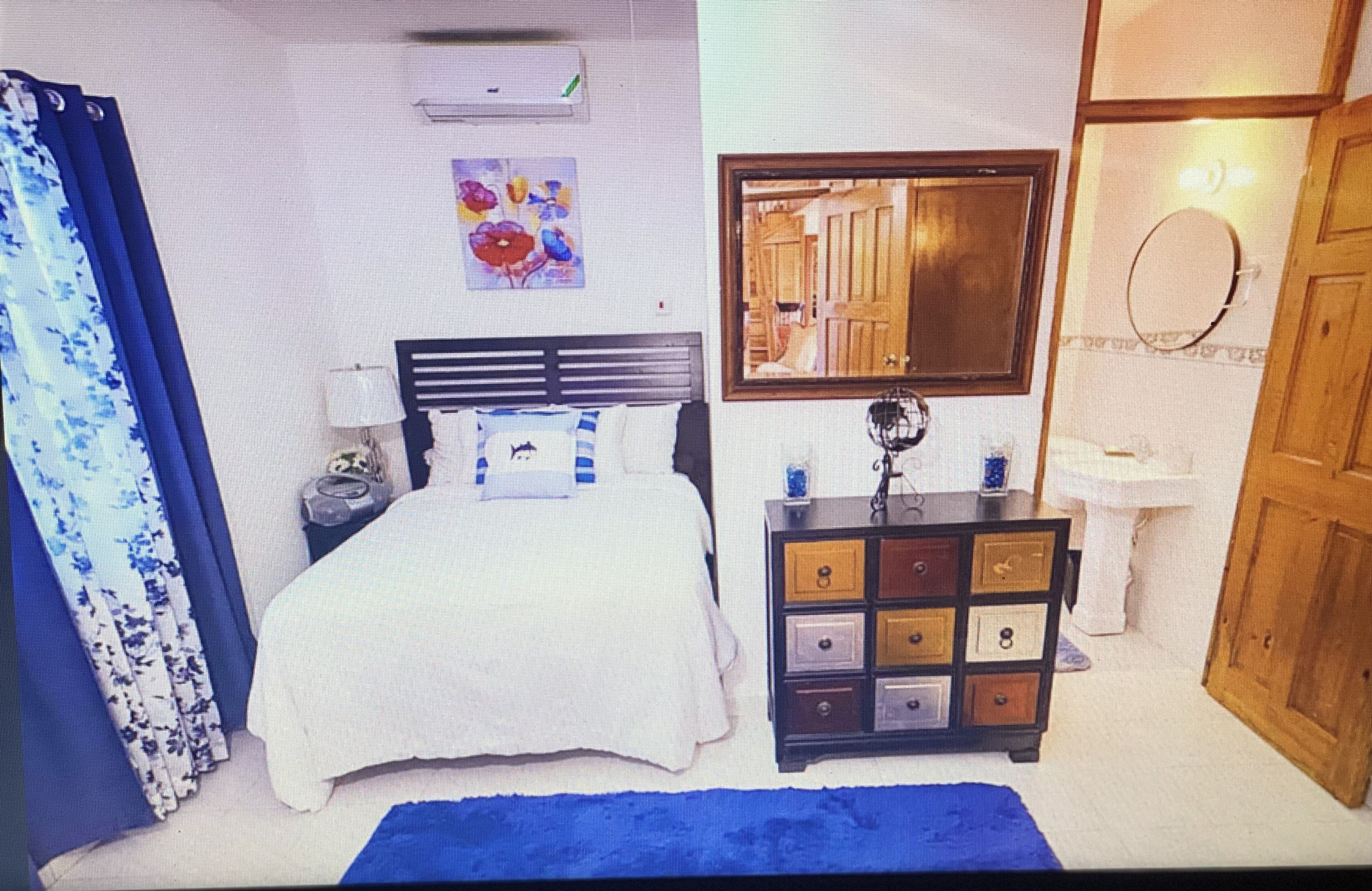 Um quarto com cama, penteadeira e espelho.