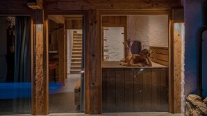 A wooden interior with a person lying on a bench.