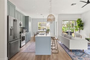 Enjoy cooking in this kitchen with a central island, bar stools, and a large window offering a view of the outdoors.