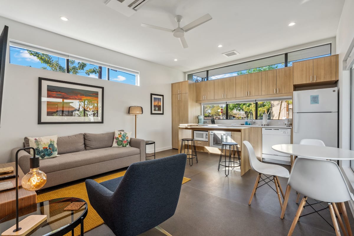 Una sala de estar moderna con un sofá, una mesa de centro y un comedor con una mesa y sillas.
