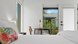 A bedroom with a bed, a nightstand, a table with chairs, and a view of the outside. - 4Square Complex (Phoenix)