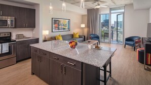 A modern kitchen with dark wood cabinets, stainless steel appliances, and a granite countertop. - 2BD/Austin - Full Kitchen, W/D, Balcony, Fire Pit! (Austin)