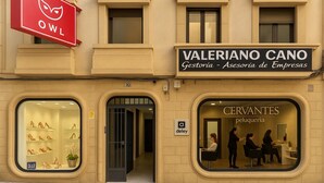 Un edificio con escaparate para 'VALERIANO CANO' y 'CERVANTES peçueria'.