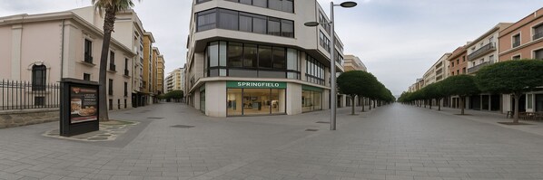 A street with a building labeled 'SPRINGFIELD' on the corner, featuring a modern design with large windows and a flat roof. - Charming Central Apartment in Jaén (Jaén)